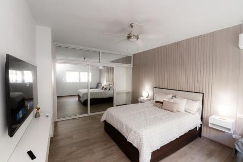 TRACADERO Ocean Pearl Suite في La Laguna: غرفة نوم بها سرير أبيض كبير ومرآة