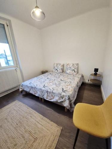 a bedroom with a bed and a yellow chair at Appart 4 chambres Idéal travailleurs et familles in Saint-Nazaire