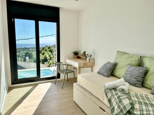 a bedroom with a bed and a desk and a window at Les Flors de Cunit Villa Cedra in Cunit