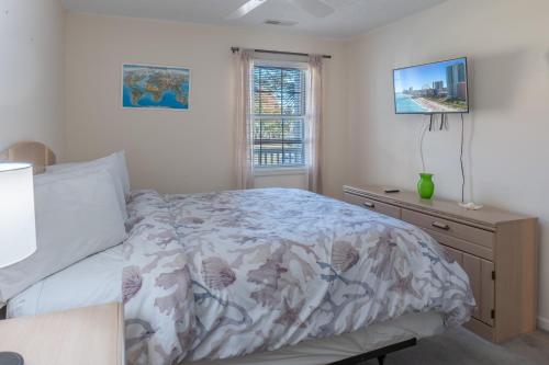 una camera da letto con un letto, un comò e una finestra di Charming Golf Getaway! River Oaks 19E a Myrtle Beach