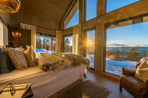 ein Schlafzimmer mit einem Bett und einem großen Fenster in der Unterkunft Luxurious Mountain Lodge in Ljørdal