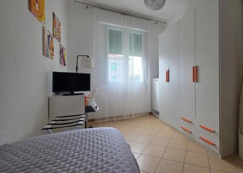 ein Schlafzimmer mit einem Bett und einem Fernseher darin in der Unterkunft ᑢᗩSᗩ ᘻᗩᖴᗩᒪᗪᗩ zona stazione - teatro - centro con parcheggio interno in Imola