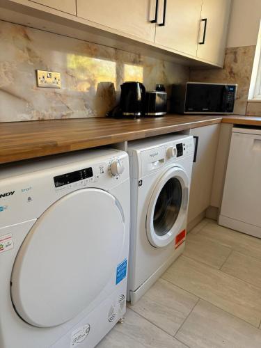 a kitchen with a washing machine and a counter at Stansted Stop Over in Takeley