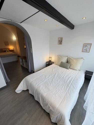 a bedroom with a large white bed in a room at Spacieux duplex sur le port in Gruissan