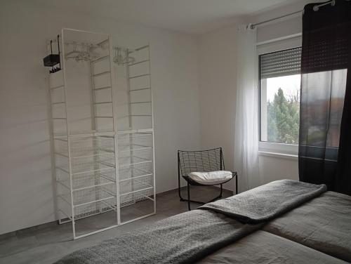 Sveti Jurij ob ŠčavniciApartment Jamna - FREE ticket Bioterme的一间卧室，里面有一张床、一把椅子和一扇窗户