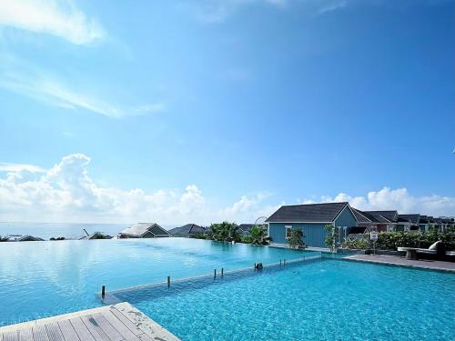 une grande piscine avec l'océan en arrière-plan dans l'établissement Nova Word Phan Thiết - The Moon The Moon Villa, à Bình Tú