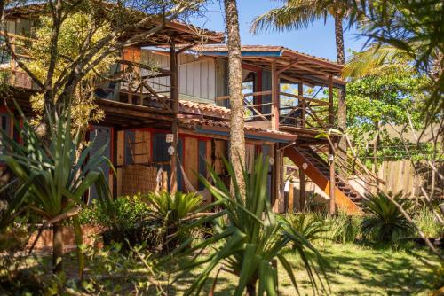 a house with palm trees in front of it at Pousada Canto Bravo in Ilhabela