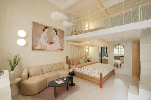 ein großes Wohnzimmer mit einem Sofa und einem Bett in der Unterkunft Lebatriu in Hanoi