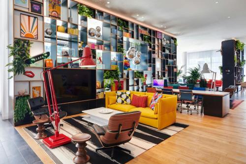 a living room with a yellow couch and a tv at citizenM Washington DC NoMa in Washington, D.C.