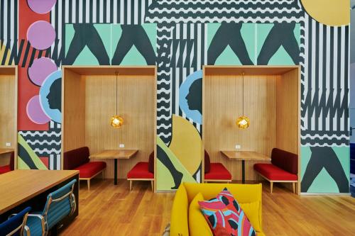 a restaurant with tables and chairs and colorful walls at citizenM Washington DC NoMa in Washington, D.C.