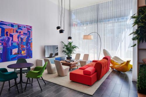 a living room with a red couch and colorful chairs at citizenM Washington DC NoMa in Washington, D.C.