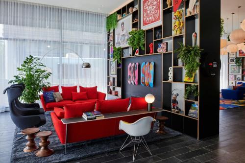 a living room with a red couch and a table at citizenM Washington DC NoMa in Washington, D.C.