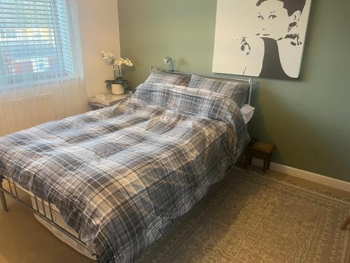 ein Bett mit einer karierten Decke in einem Schlafzimmer in der Unterkunft Number 42 in Woodstock