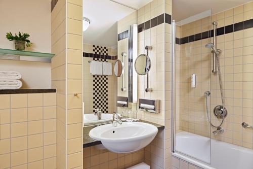 a bathroom with a sink and a shower at Lindner Hotel Cologne Am Dom, part of JdV by Hyatt in Cologne