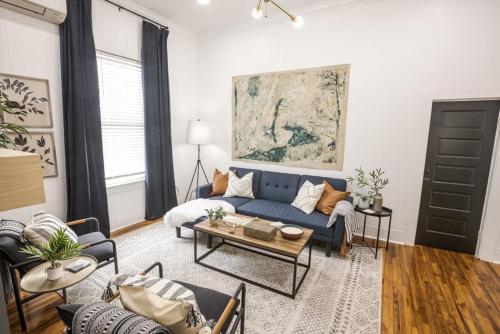 Una sala de estar con un sofá azul y una mesa. en Lafayette Getaway-Downtown House with Free Parking, en Lafayette