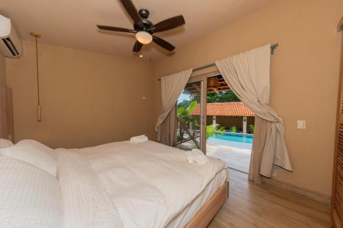 a bedroom with a bed with a ceiling fan and a window at Casa Nära Hotel in El Sucio