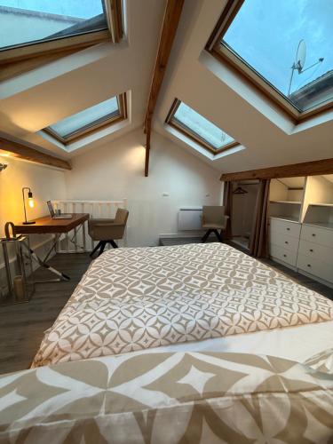 a bedroom with a large bed with skylights at LUMINEUX DUPLEX CENTRE VILLE 10 minutes de Paris Parking privée souterrain in Rueil-Malmaison