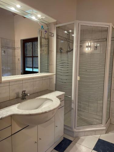 ein Badezimmer mit Waschbecken und Glasdusche in der Unterkunft Ferienwohnung Heidi in Prien am Chiemsee