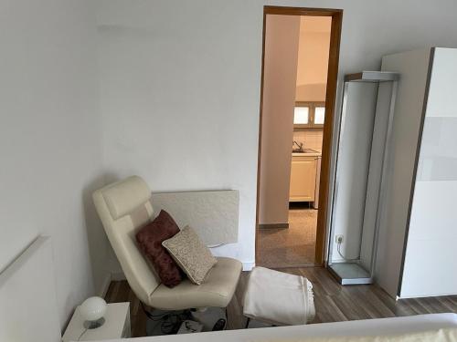 a living room with a chair and a refrigerator at Zentrales City Apartment im Zentrum aber trotzdem ruhig in Bamberg