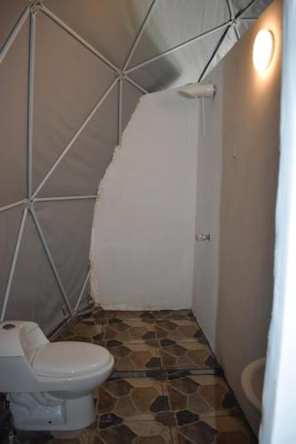 a bathroom with a toilet and a tiled floor at Casita Anya in Hone Creek