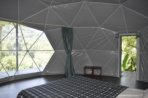 a tent with a bed in a room with windows at Casita Anya in Hone Creek