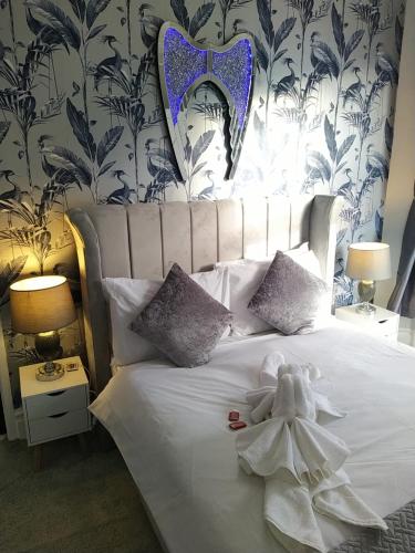 ein Schlafzimmer mit einem weißen Bett mit einem ausgestopften Tier darauf in der Unterkunft The Dreamcatcher Hotel in Blackpool