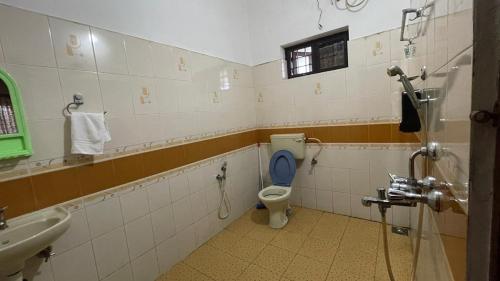 une salle de bain avec des toilettes bleues et un lavabo dans l'établissement Homestay near Lulu- Edappally- Amrita, Aster Hospital- Kochi, à Ernakulam