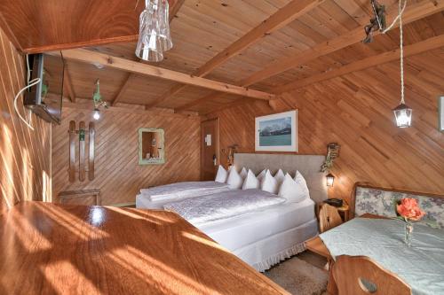 a bedroom with two beds in a room with wooden walls at Hotel Tirol in Treze Tílias