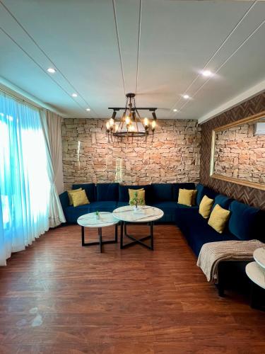 a living room with a blue couch and two tables at Ortus - Murree Hills in Murree