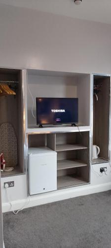 a white entertainment center with a tv on it at The Dreamcatcher Hotel in Blackpool