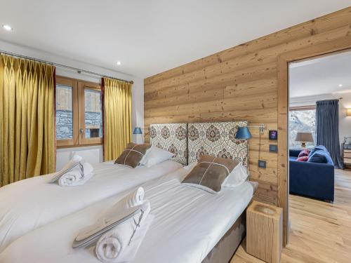 deux lits dans une chambre aux murs en bois dans l'établissement Charmant appart avec terrasse, parking, WIFI - FR-1-452-390, à Saint-Martin-de-Belleville