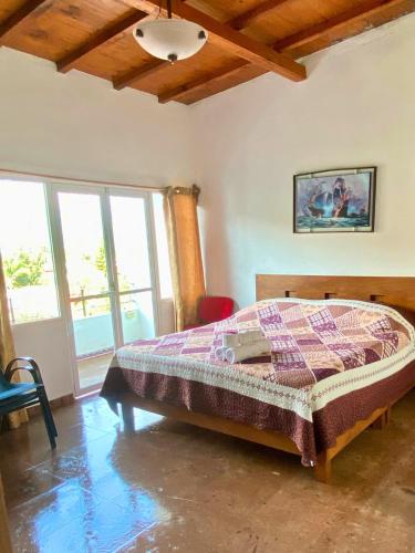 a bedroom with a bed in a room with windows at Hotel Casa Maximiliano in Tepoztlán