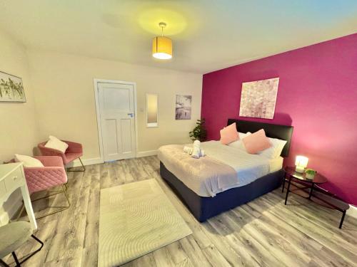 a bedroom with a bed and a purple wall at Beachside Haven in Centre with Garden and Parking - 5 Mins Walk to The Beach in Bournemouth
