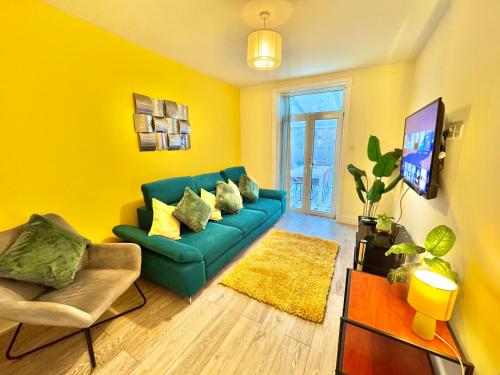 a living room with a green couch and yellow walls at Beachside Haven in Centre with Garden and Parking - 5 Mins Walk to The Beach in Bournemouth