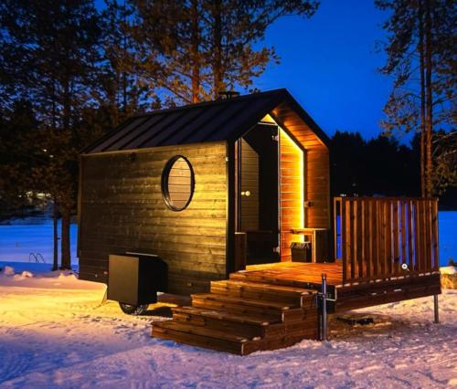 a small wooden cabin with stairs in the snow at Arctic circle cabin 1 in Rovaniemi