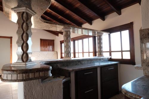 una cucina con piano in pietra e finestre di Duplex Espaçoso - Praia e Centro - Garagem Fechada e Área Gourmet a Xangri-lá