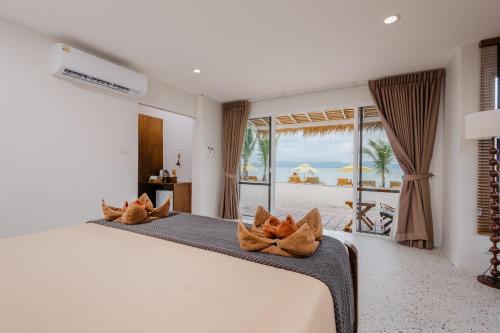 a bedroom with a bed with a view of the beach at Sea Escapes Resort in Thongsala
