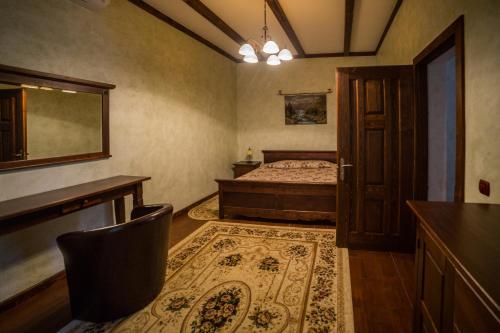 a bedroom with a bed and a table and a chair at Gnizdo Golubky in Shaian