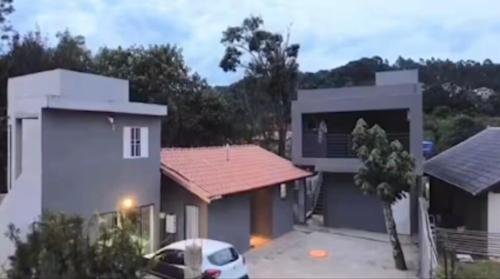 a house with a car parked in front of it at Studio Jaguary - Monte Verde in Camanducaia