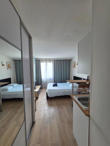 a hotel room with two beds and a kitchen at Joli studio Disneyland Paris 2 pers in Bussy-Saint-Georges