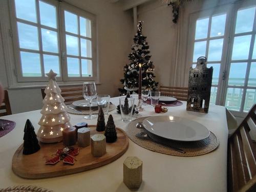 een eettafel met een kerstboom erop bij Villa Bellevue - Anglo-Norman seafront house in Ouistreham