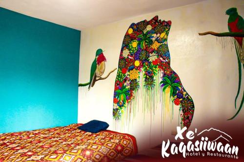 a bedroom with a wall with a peacock painting on the wall at Xe 'Gakasiiwaan in San Juan La Laguna