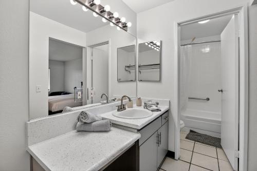 a white bathroom with a sink and a shower at Bright modern studio featuring full kitchenette in Las Vegas