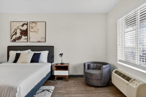a bedroom with a bed and a chair at Bright modern studio featuring full kitchenette in Las Vegas