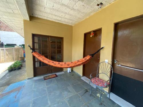 een veranda met een hangmat aan de zijkant van een huis bij kitinet centro econômico in Santo Antônio do Pinhal