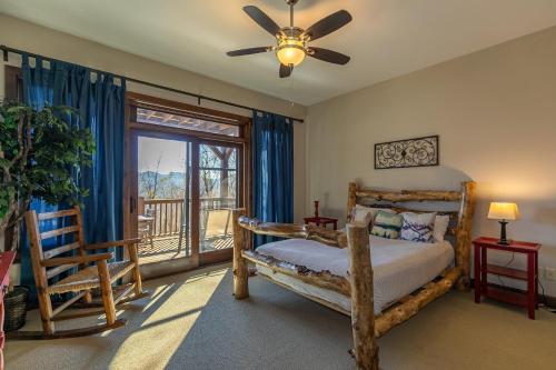 una camera con letto, ventilatore a soffitto e finestra di Banner Crest a Banner Elk