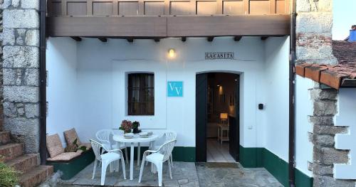 eine Terrasse mit einem weißen Tisch und Stühlen in der Unterkunft La Casita de Llanes Parres in Parres de Llanes