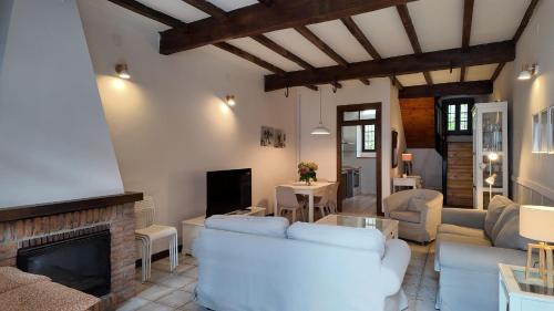 ein Wohnzimmer mit weißen Möbeln und einem Kamin in der Unterkunft La Casita de Llanes Parres in Parres de Llanes