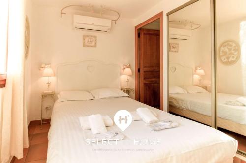 une chambre avec deux lits et un miroir dans l'établissement SELECT'SO HOME - Villa PANORAMA - Services hôteliers & prestations de qualité, au Lavandou