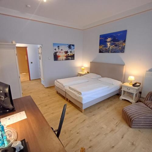 ein Schlafzimmer mit einem Bett, einem Tisch und einer Couch in der Unterkunft TRIP INN PostHotel Düren in Düren - Eifel